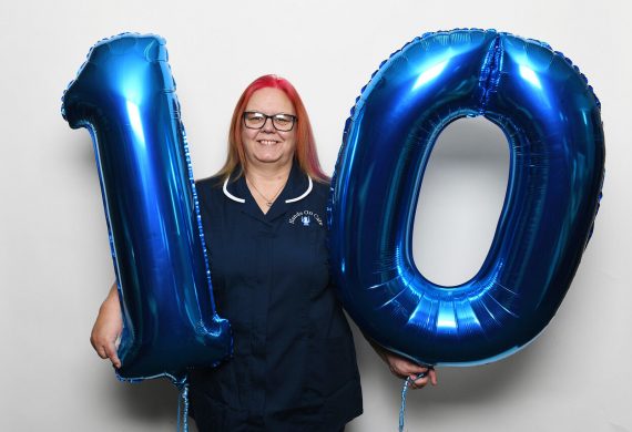 Hands on Care worker holding number 10 balloons