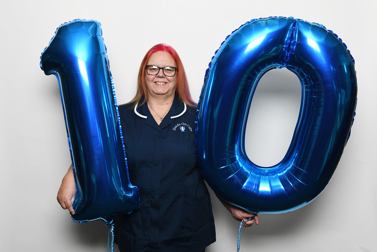 Hands on Care worker holding number 10 balloons