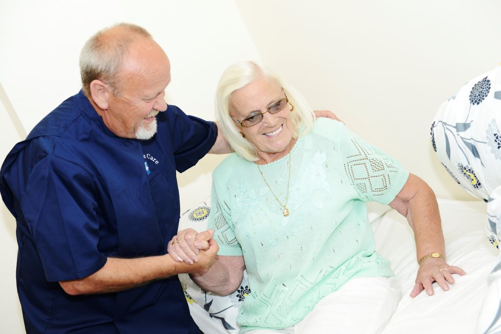 Hands on Care caregiver helping a resident up