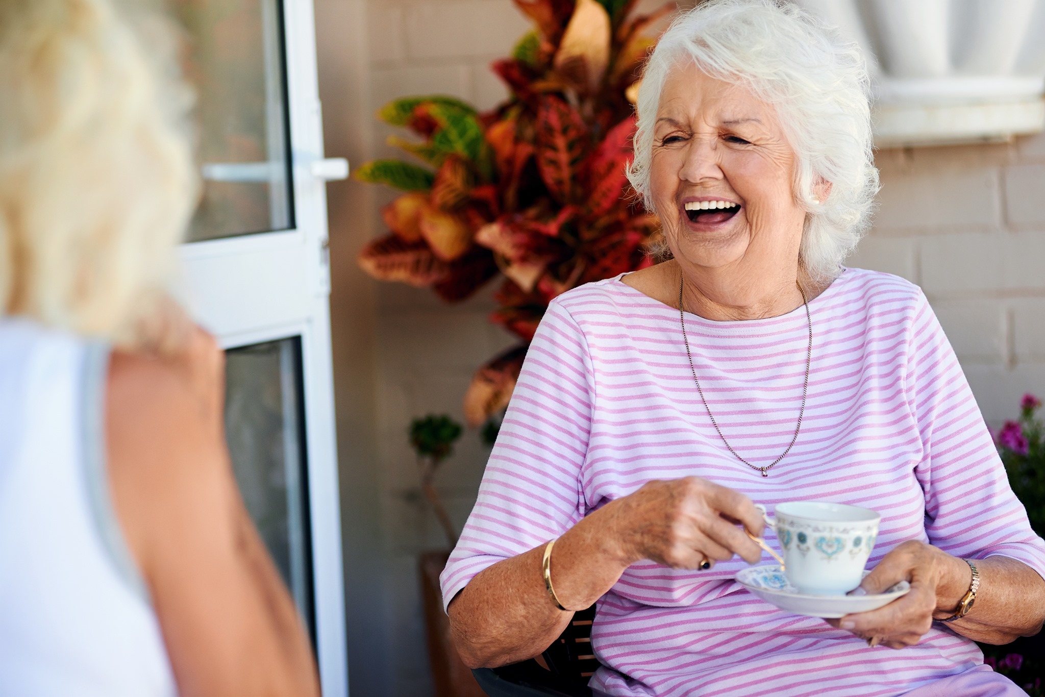 Resident laughing while enjoying a cup of tea