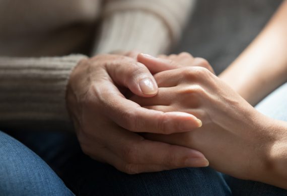 A close up of two people holding hands.