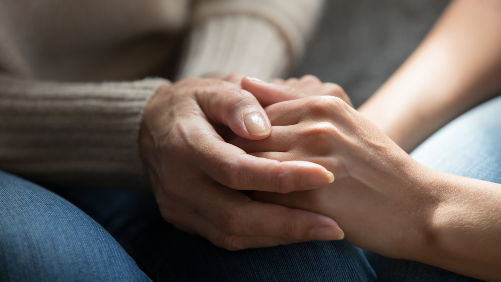 A close up of two people holding hands.