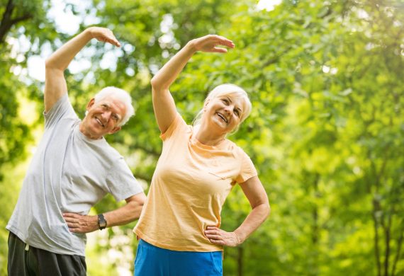 An elderly couple performing yoga