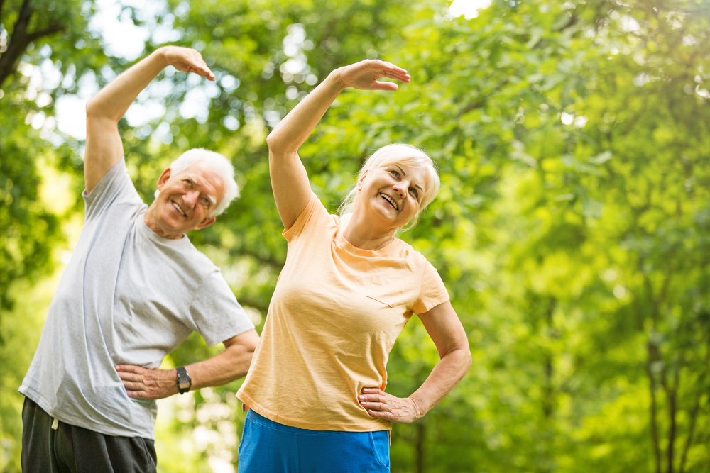 An elderly couple performing yoga