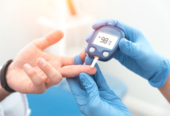 Caregiver checking someone's blood who has diabetes.