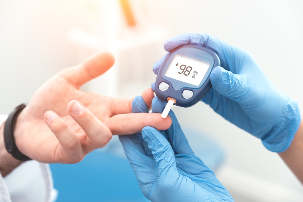 Caregiver checking someone's blood who has diabetes.