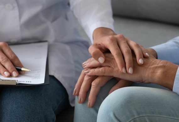 Close up of a career and resident hands embracing