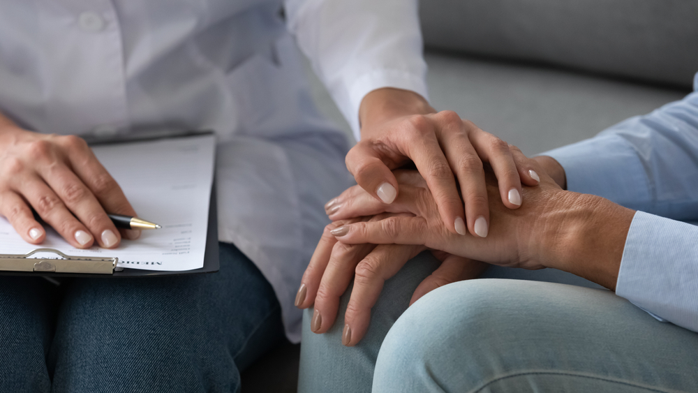 Close up of a career and resident hands embracing